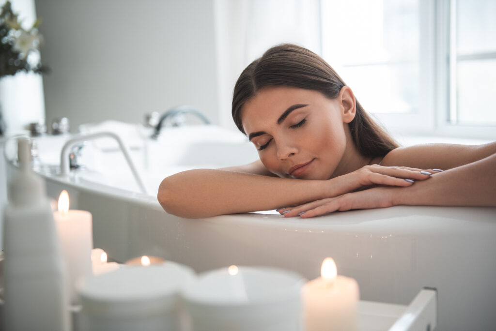 Mulher com expressão serena relaxando dentro de banheira